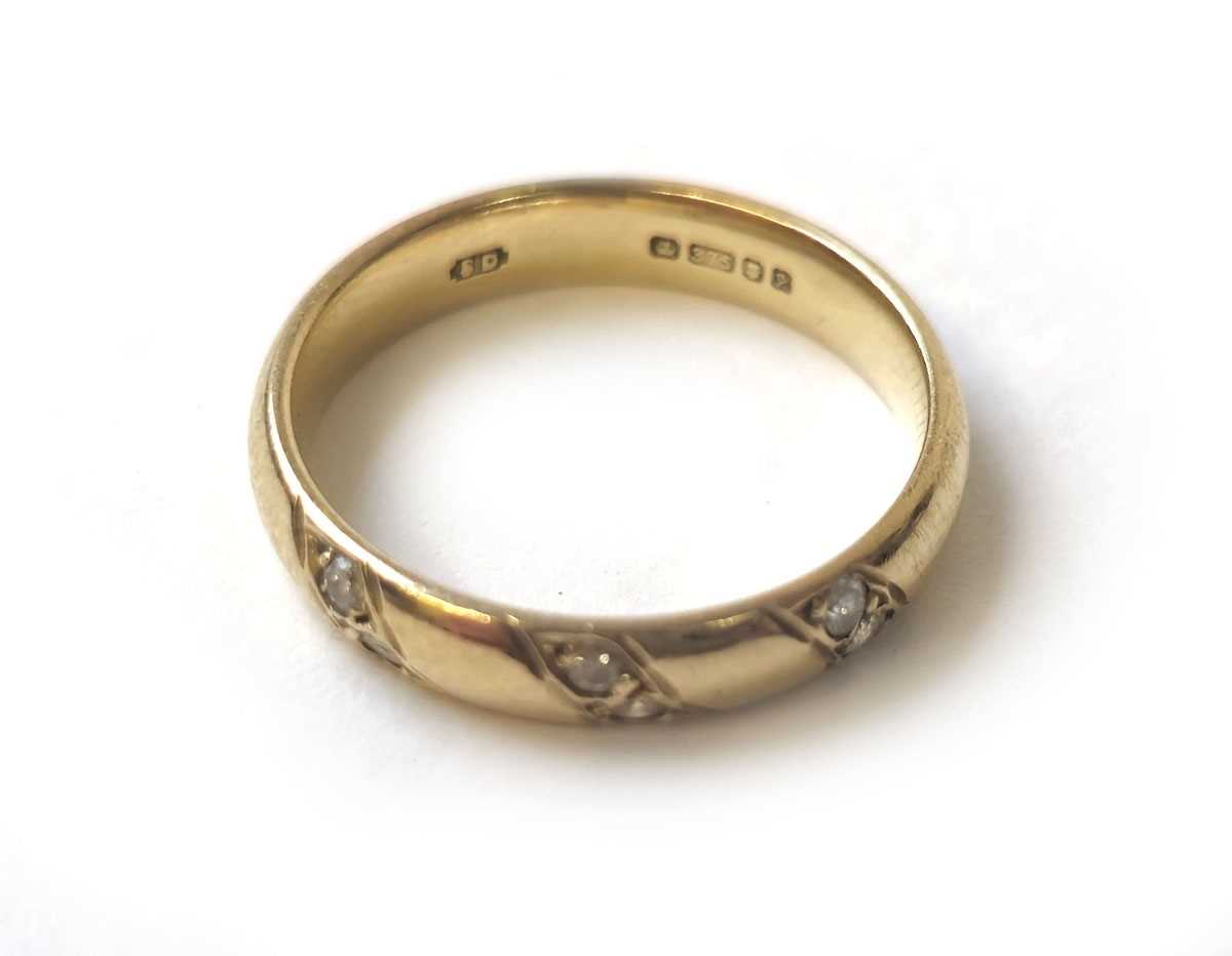 Lot 407 - A 9ct gold band set with three diagonal lines...