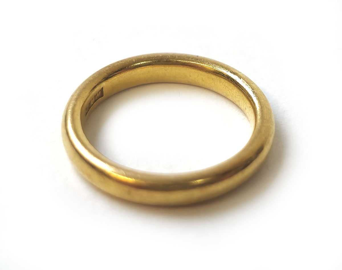 Lot 410 - A 22ct gold court shaped wedding band. Approx....