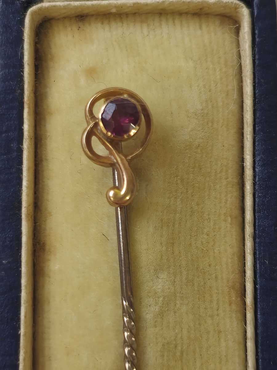 Lot 420 - A yellow metal and amethyst stick pin in box....