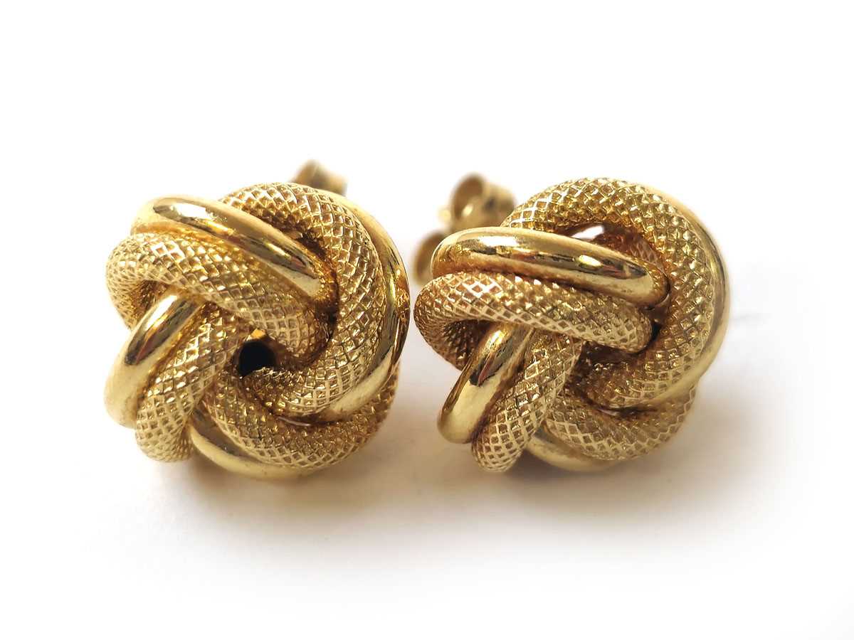 Lot 427 - A pair of 18ct gold knot earrings. Approx....