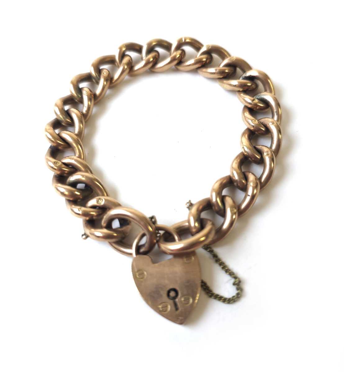 Lot 434 - A yellow metal curb bracelet with heart...