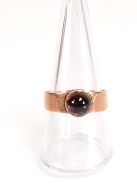 Lot 559 - A yellow metal ring set cabochon red stone in...