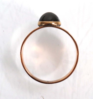 Lot 559 - A yellow metal ring set cabochon red stone in...