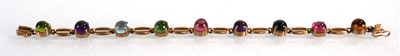 Lot 560 - A 9ct yellow gold bracelet set nine coloured...