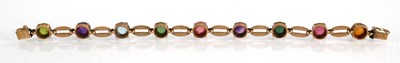 Lot 560 - A 9ct yellow gold bracelet set nine coloured...