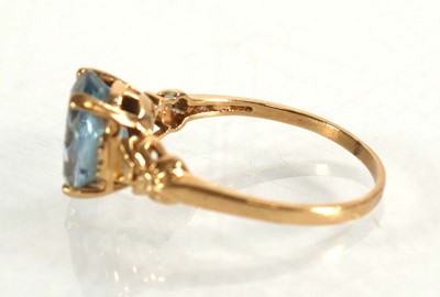 Lot 564 - A yellow metal ring set oval pale blue topaz...