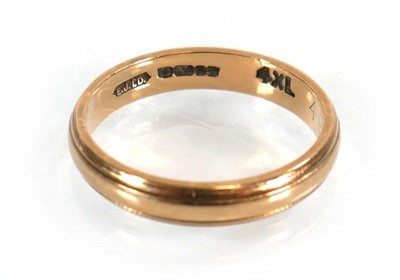 Lot 565 - A 9ct yellow gold wedding band with reeded...