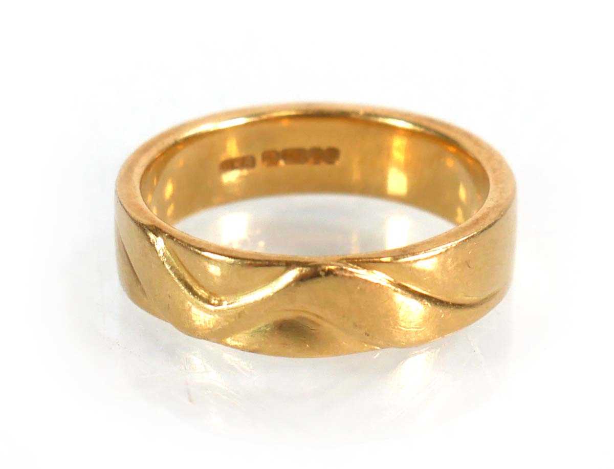 Lot 570 - An 18ct yellow gold wedding band with wave...