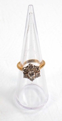Lot 586 - An 18ct yellow gold cluster ring set seven...