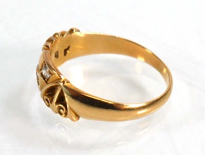 Lot 597 - An 18ct yellow gold ring set three small...