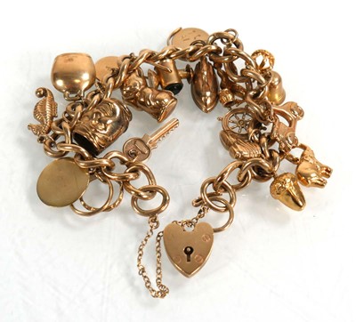 Lot 624 - A 9ct yellow gold curblink bracelet with heart...