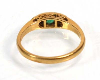 Lot 637 - An 18ct yellow gold ring set emerald and two...