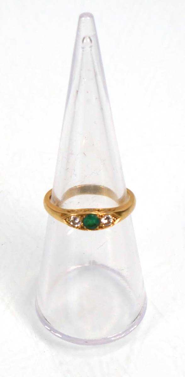 Lot 637 - An 18ct yellow gold ring set emerald and two...