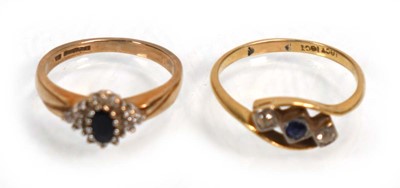 Lot 640 - An 18ct yellow gold crossover ring set blue...
