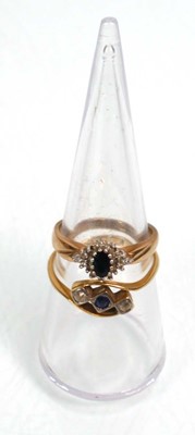 Lot 640 - An 18ct yellow gold crossover ring set blue...
