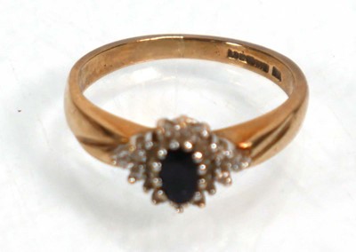 Lot 640 - An 18ct yellow gold crossover ring set blue...