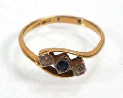 Lot 640 - An 18ct yellow gold crossover ring set blue...