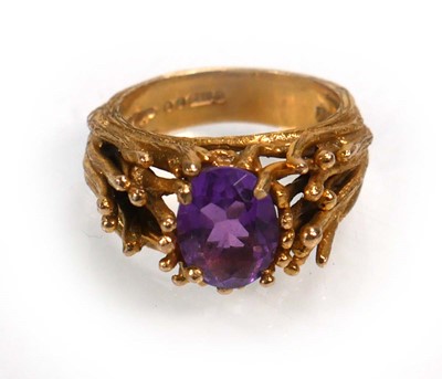 Lot 653 - A 9ct yellow gold ring set oval purple stone...