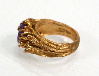 Lot 653 - A 9ct yellow gold ring set oval purple stone...