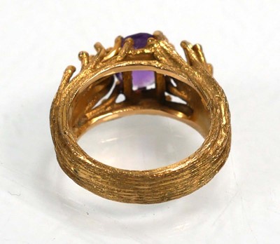 Lot 653 - A 9ct yellow gold ring set oval purple stone...