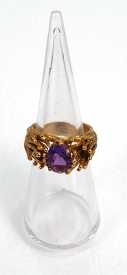 Lot 653 - A 9ct yellow gold ring set oval purple stone...