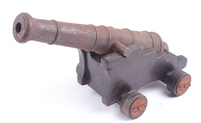 Lot 1119 - An ornamental iron cannon, overall 14 ins, on...