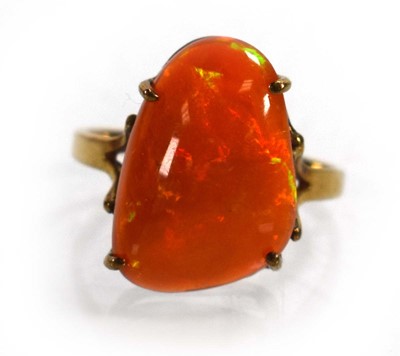 Lot 672 - A yellow metal ring set fire opal in a four...