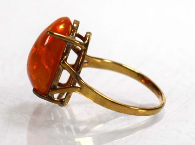 Lot 672 - A yellow metal ring set fire opal in a four...