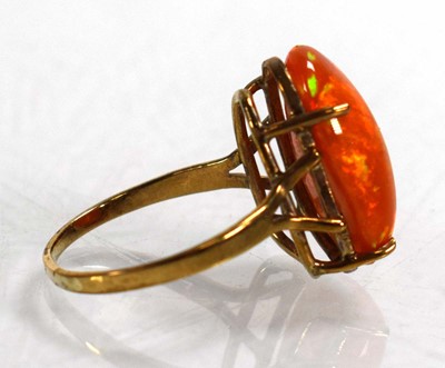 Lot 672 - A yellow metal ring set fire opal in a four...