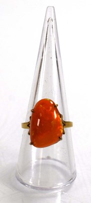 Lot 672 - A yellow metal ring set fire opal in a four...
