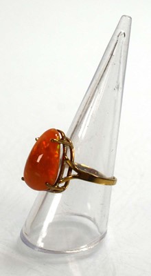 Lot 672 - A yellow metal ring set fire opal in a four...