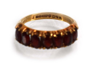 Lot 675 - A 9ct yellow gold ring set seven oval garnets,...