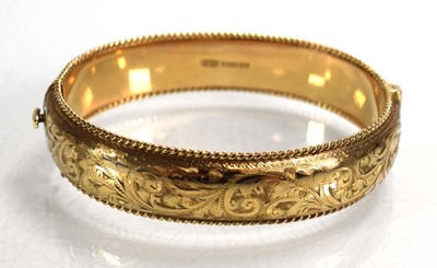 Lot 683 - A 9ct yellow gold florally engraved hinged...