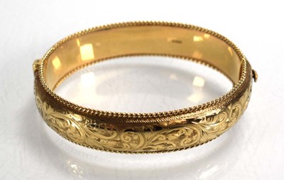 Lot 683 - A 9ct yellow gold florally engraved hinged...