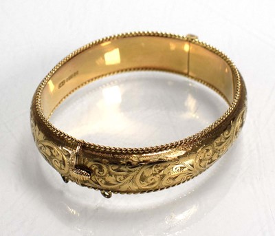 Lot 683 - A 9ct yellow gold florally engraved hinged...