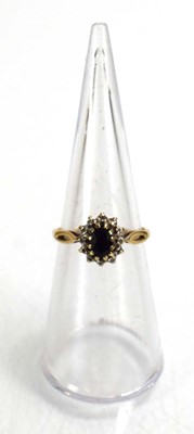 Lot 687 - A 9ct yellow gold sapphire and diamond cluster...
