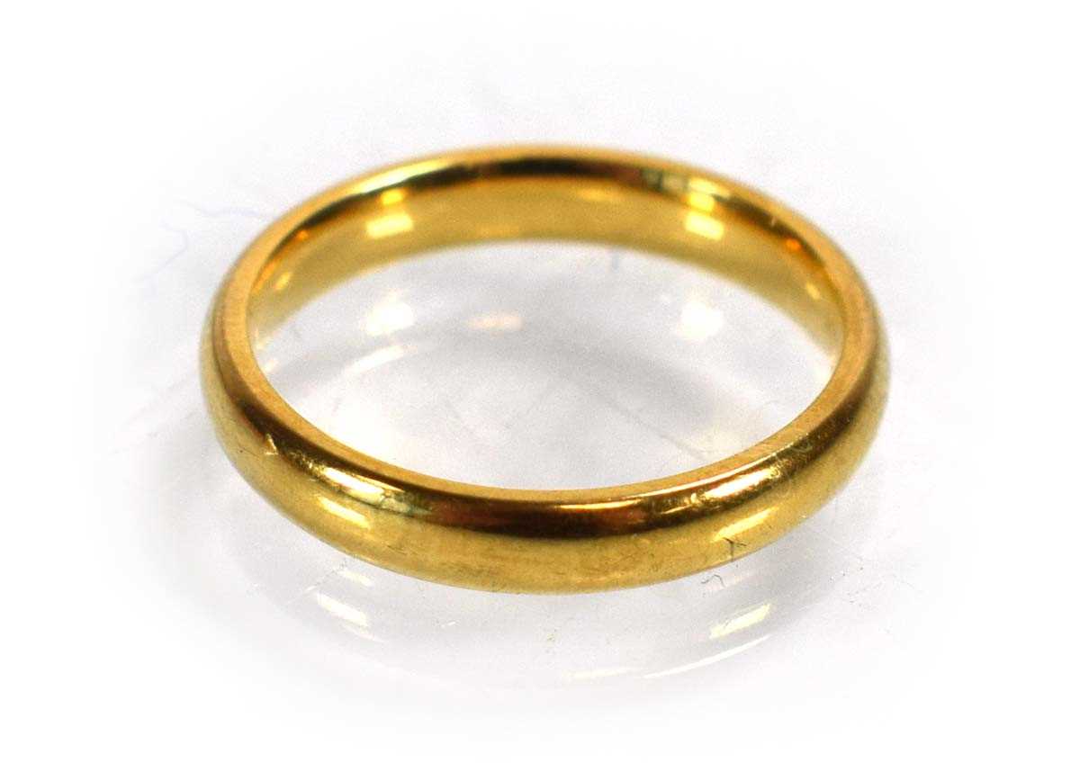 Lot 689 - An 18ct yellow gold wedding band, Birmingham...
