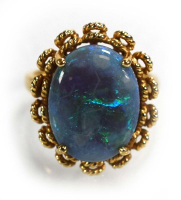 Lot 694 - A 14ct yellow gold ring set oval opal in a...