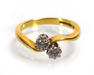 Lot 717 - An 18ct yellow gold crossover ring set two...