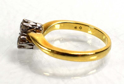 Lot 717 - An 18ct yellow gold crossover ring set two...
