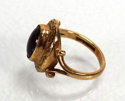 Lot 712 - A 9ct yellow gold ring set cabochon garnet in...