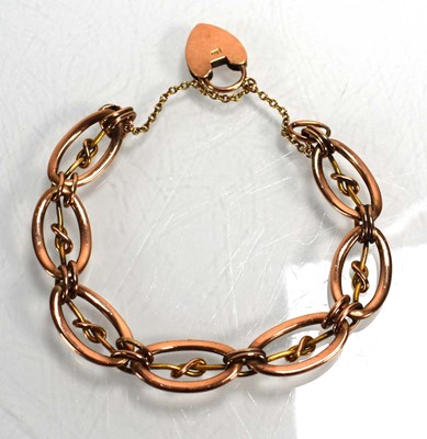 Lot 730 - A 9ct rose gold oval link bracelet with heart...