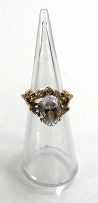 Lot 724 - A 9ct yellow gold ring set oval and trilliant...