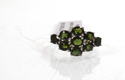 Lot 762 - A 9ct white gold ring set nine oval green...