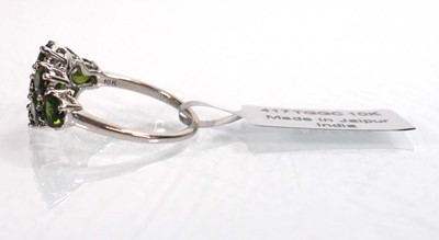 Lot 762 - A 9ct white gold ring set nine oval green...