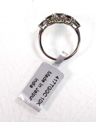 Lot 762 - A 9ct white gold ring set nine oval green...