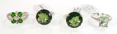 Lot 795 - Four silver dress rings set green stones,...