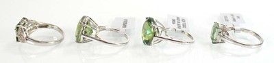 Lot 795 - Four silver dress rings set green stones,...
