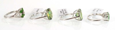 Lot 795 - Four silver dress rings set green stones,...