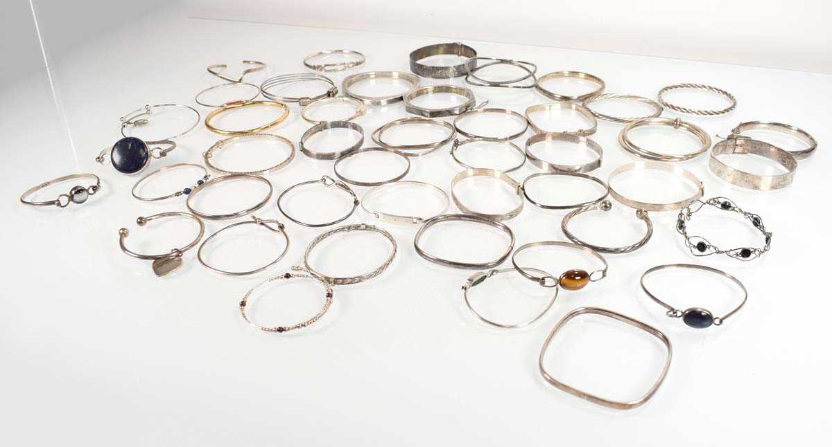 Lot 827 - A collection of silver and metalware bangles...